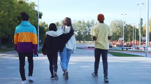 Friends walking and talking in an urban park