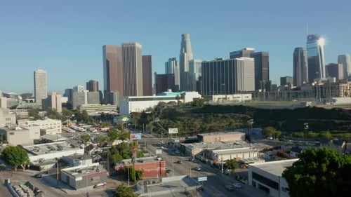 AERIAL: Flying away from Downtown Los Angeles, California Skyline at beautiful blue sky