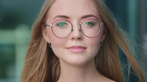 Closeup Headshot Portrait of Smiling Millennial Woman in Glasses Posing Isolated on Blue Studio