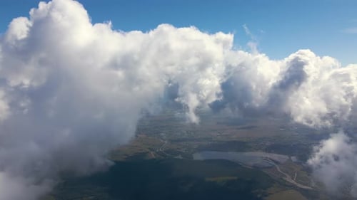 Aerial View From Airplane Window at High Altitude of Earth Covered with White Puffy Cumulus Clouds