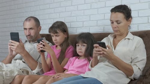 Family Engrossed in Their Cell Phones at Home