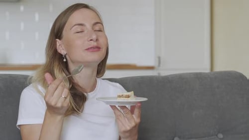 Woman Enjoying Cake with Spoon at Home