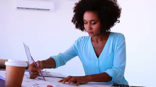 Female architect working on blueprint over drafting table 4k