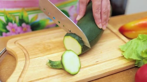 Woman Slicing Fresh Zucchini on Cutting Board
