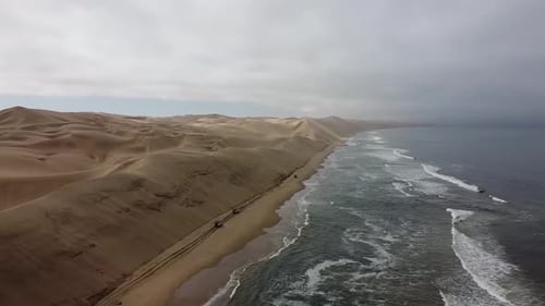 Aerial view on the desert with big sand dunes on the background of the ocean