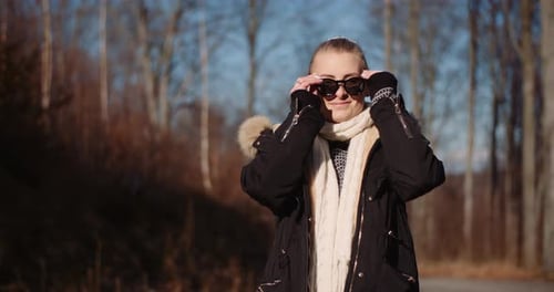 Woman Wearing Sunglasses Walks in Autumn Park