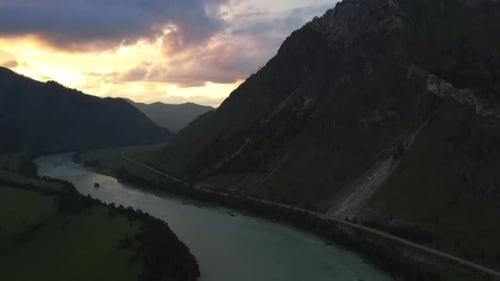 Katun river and road in valley of Altai at sunset time with dramatic sky