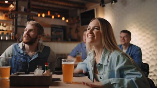 Friends Cheering at a Bar Watching Sports
