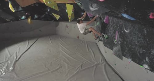 Man Indoor Rock Climbing on Multicolored Wall
