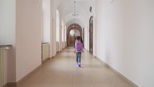 Girl Walks Down School Hallway with Purple Backpack