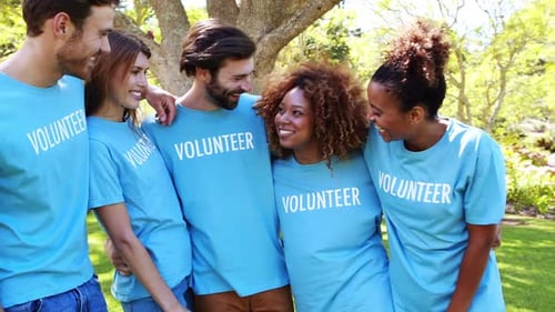 Smiling Volunteers Standing Together in a Green Park