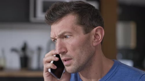 Angry Man Talking on Cell Phone Indoors