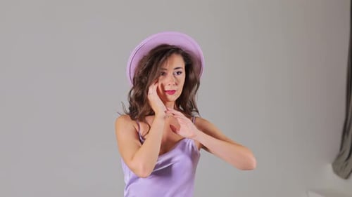 Elegant Woman Posing in a Studio with Hat