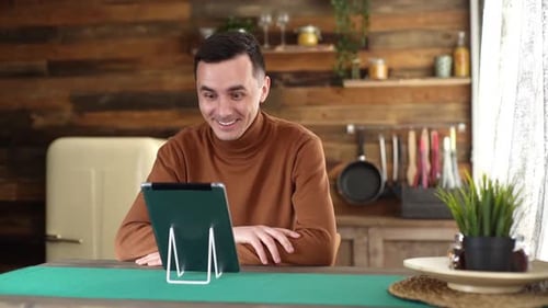 Man Using Tablet for Video Call in Kitchen