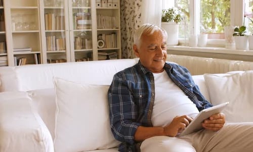Older Man Relaxing at Home Using Tablet