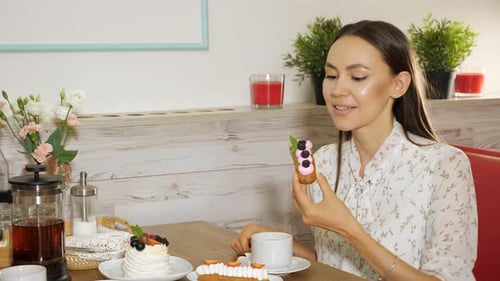 Happy Girl Eats Tasty Cake with Berries in Modern Sweet Shop