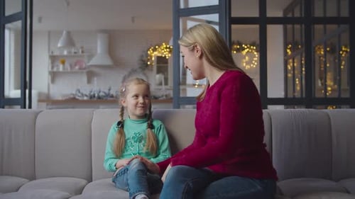 Blonde Woman and Girl Chatting on Couch Indoors