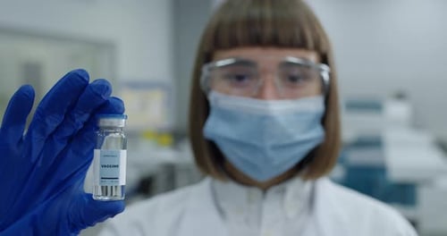 Medical Professional Holds Vaccine Vial in Laboratory Setting