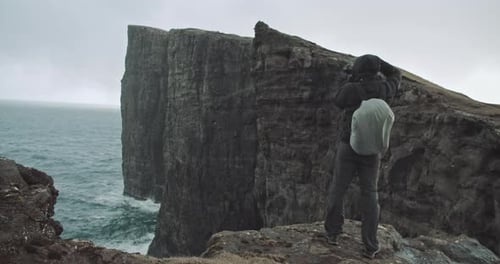 Un homme prend une photo au sommet d'une montagne