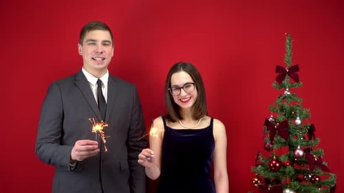 Festive Couple with Sparklers and Christmas Tree