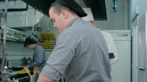 Trainee Cook Putting Champignons on a Frying Pan