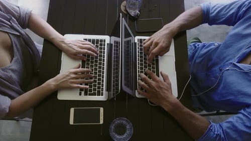 Man and Woman Working on Laptops Together
