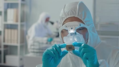 Scientist Examining Microchip in Cleanroom Laboratory