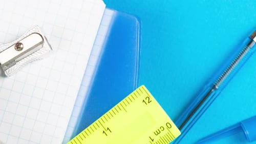 School Supplies Lie on a Pastel Blue Background Together with
