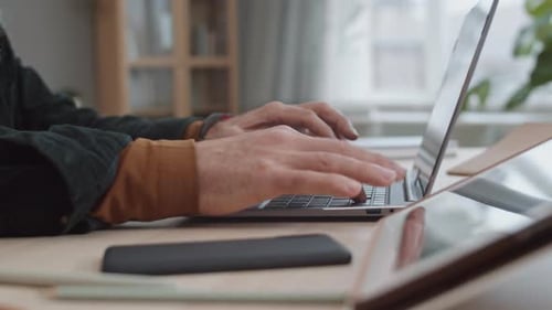 Adult Typing on Laptop Computer in Home Office