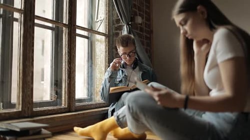 Young Man and Woman Reading Indoors