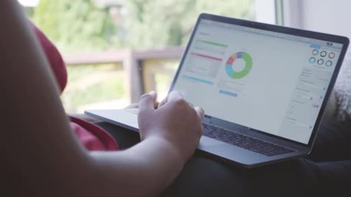 Working on Laptop with Charts and Graphs Indoors