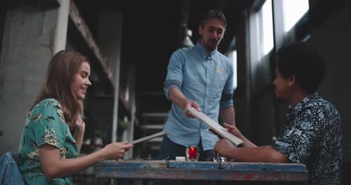 Young couple sitting at a restaurant table waiter brings menucarts for them