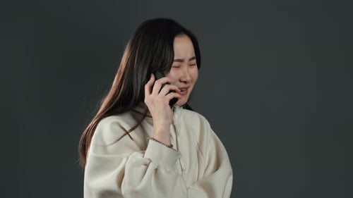 Woman Talking on Phone with Gray Background