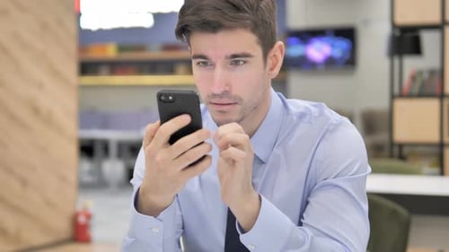 Man is Shocked by News on his Phone