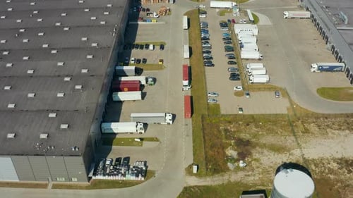 Park with Warehouse Loading Hub with Many Trucks Aerial View