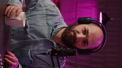 Man with Coffee Podcasting with Headphones and Microphone