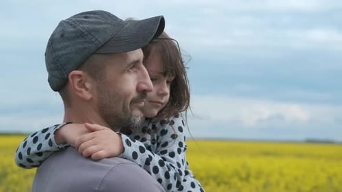 Father and Daughter Embrace in Yellow Field