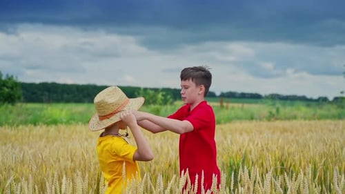 El hermano mayor pone sombrero de paja en la cabeza del niño más pequeño.