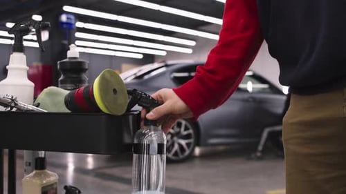 Car Detailer Using Cleaning Supplies in Garage
