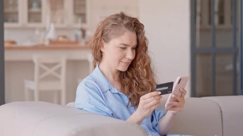 Woman Shops Online with Phone and Credit Card