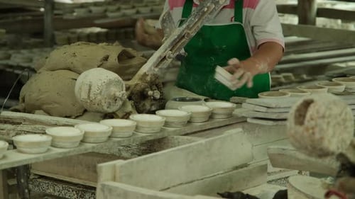 Woman making clay objects in pottery workshop. The process of making a handmade ceramic bowl.