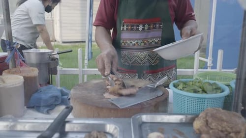 Street Food Stall With Male Vendor Chopping Meat In Bangkok Thailand