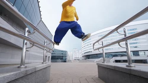Free Running Young Man Runs Over Obstacles in the City on Training Area Near Modern Buildings Slow