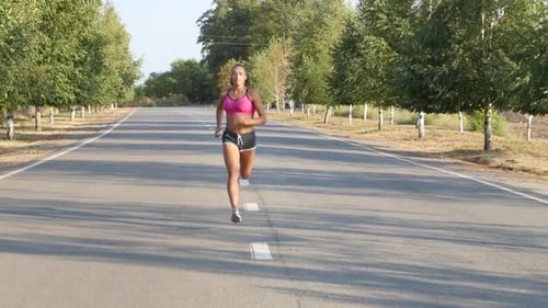 Beautiful Sportswoman Running on a Country Road. Training Outdoors