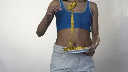 Woman Eating Measuring Tape with Fork
