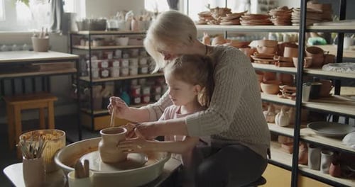 Child Learning Pottery with Instructor in Studio
