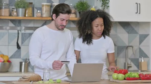 Mixed Race Couple Making Online Payment on Laptop