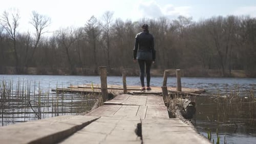 Girl on the Old Wooden Pier on Lake. Rustic Style Concept.