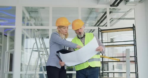 Woman Manager in Hardhat Discussing Details of Building Project Together with Professional Engineer
