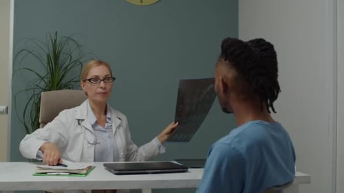 Doctor Showing X-Ray to Patient in Office